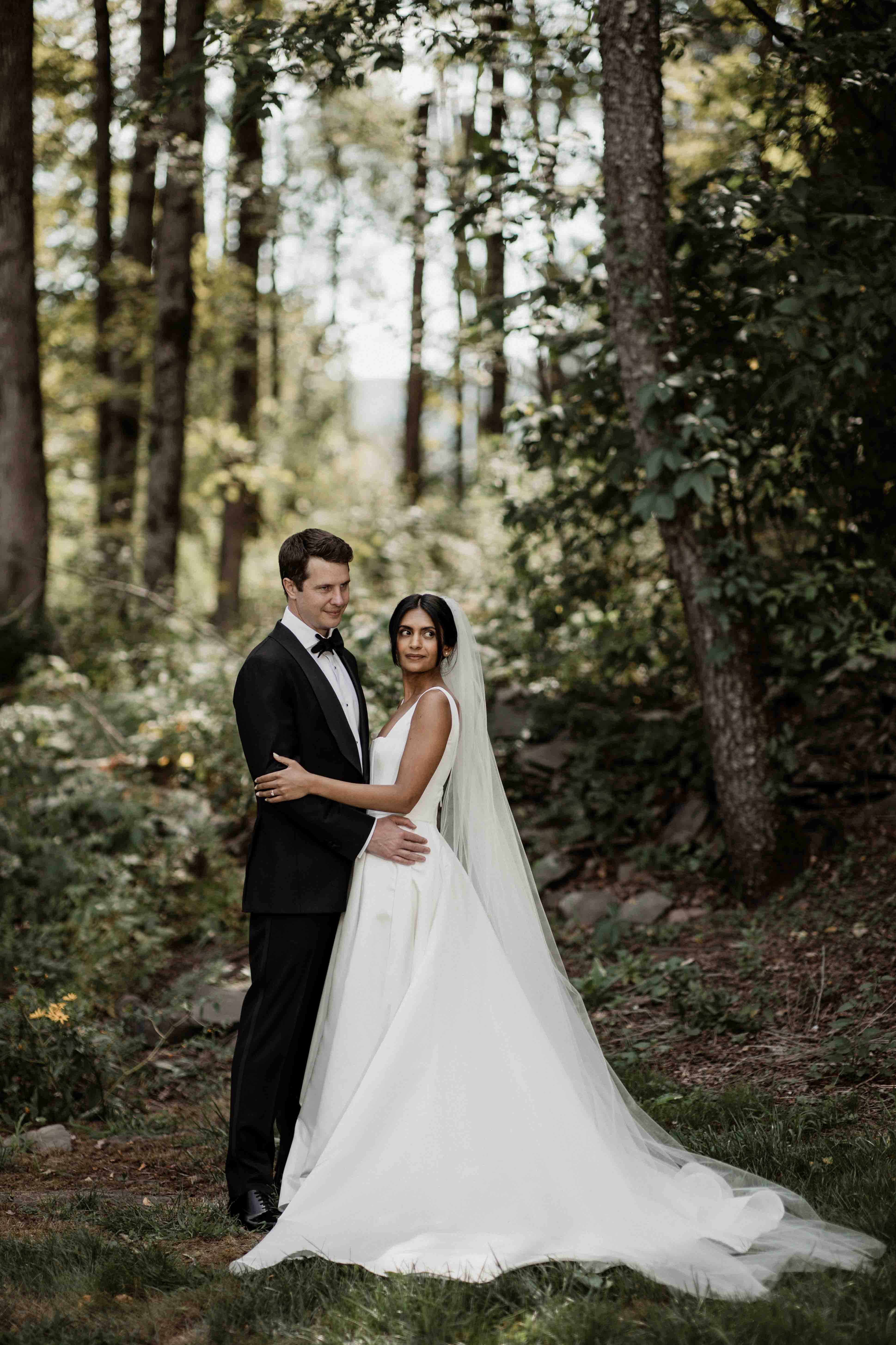 Couple's portrait in the pine grove during golden hour light
